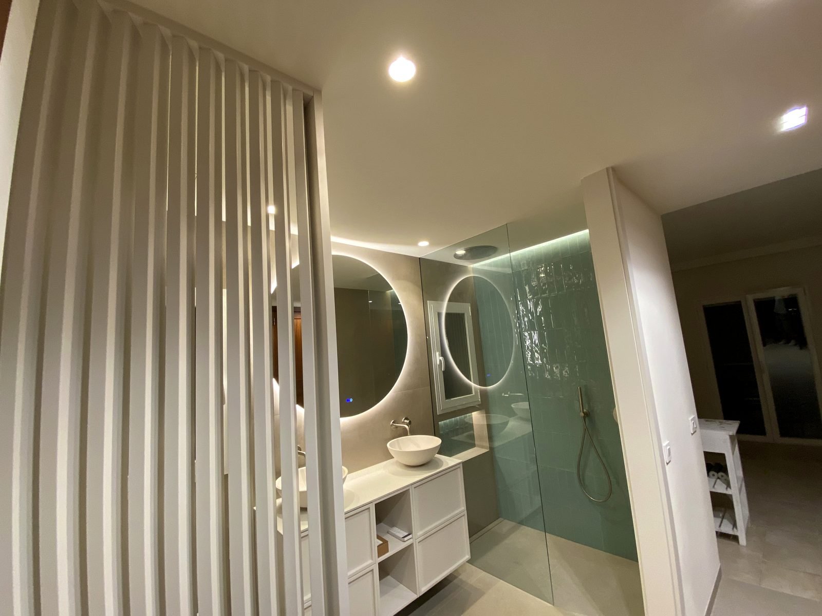 Baño con lamas y espejo retroiluminado
